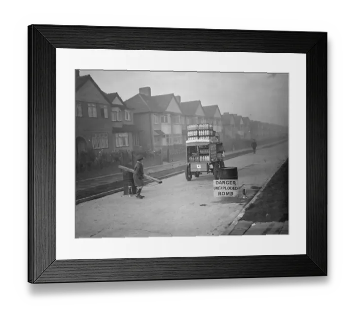 Framed Print : 9 November 1940 The milkman is allowed through the barrier to a street in his rounds