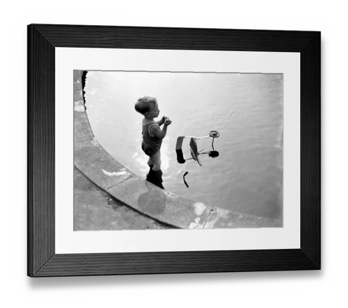 Framed Print : Toddler and his trike in the water. 1933