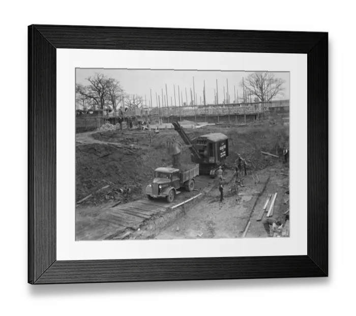 Framed Print : Digger clears the land and puts soil into the back of Bedford truck on the site of Framed Print : Digger clears the land and puts soil into the back of Bedford truck on the site of