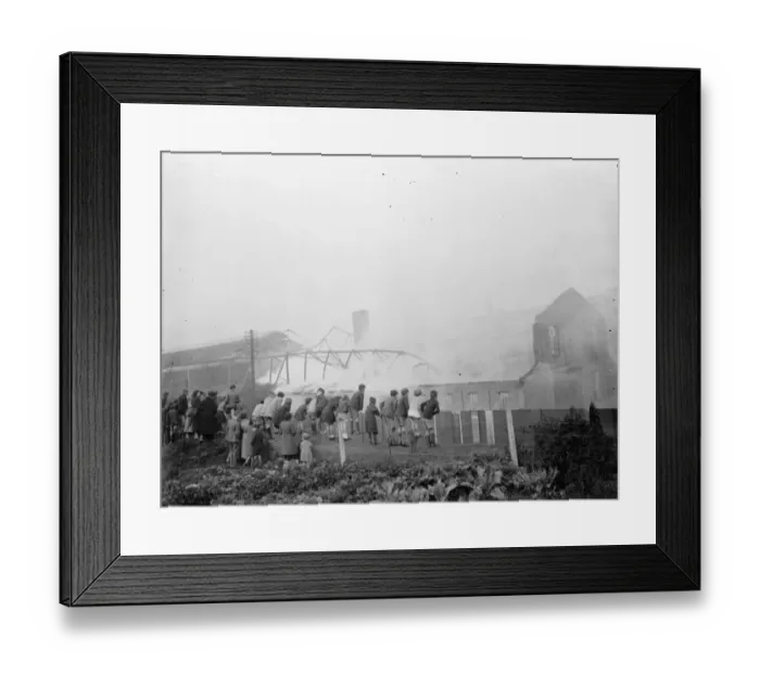 Framed Print : Children climb on a fence to watch the fire at the Vickers factory in Crayford, Kent