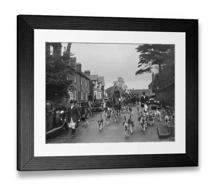 Framed Print : Hunting scenes in Bletchingley, Surrey. The hounds run through the streets ahead Framed Print : Hunting scenes in Bletchingley, Surrey. The hounds run through the streets ahead