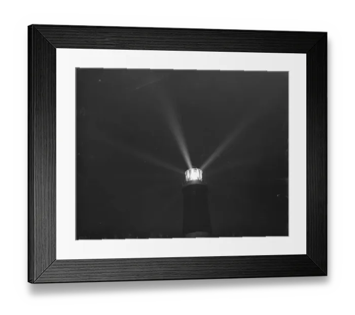 Framed Print : Dungeness lighthouse send out its light by night over Dungeness Point, Kent, which