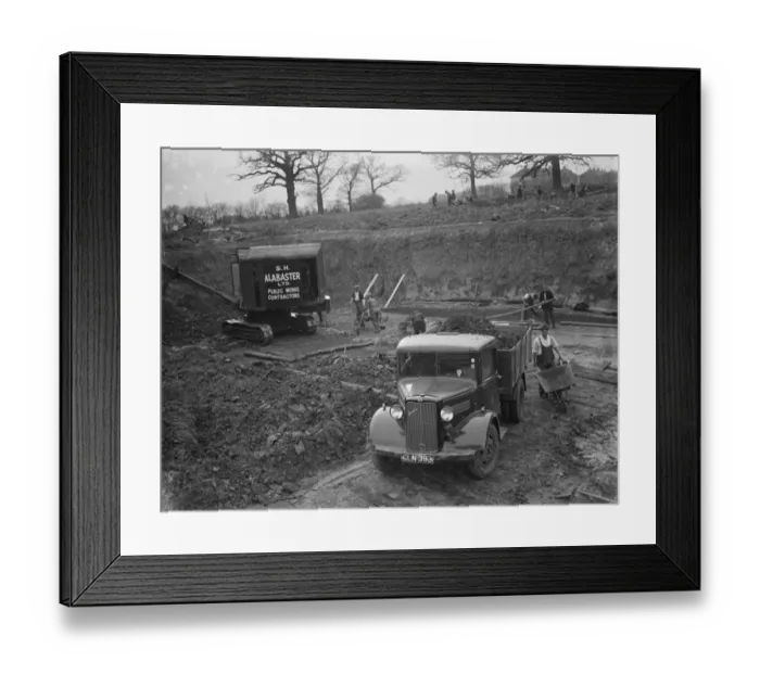 Framed Print : A Bedford truck, full of soil, pulls out of the site where the new swimming pool
