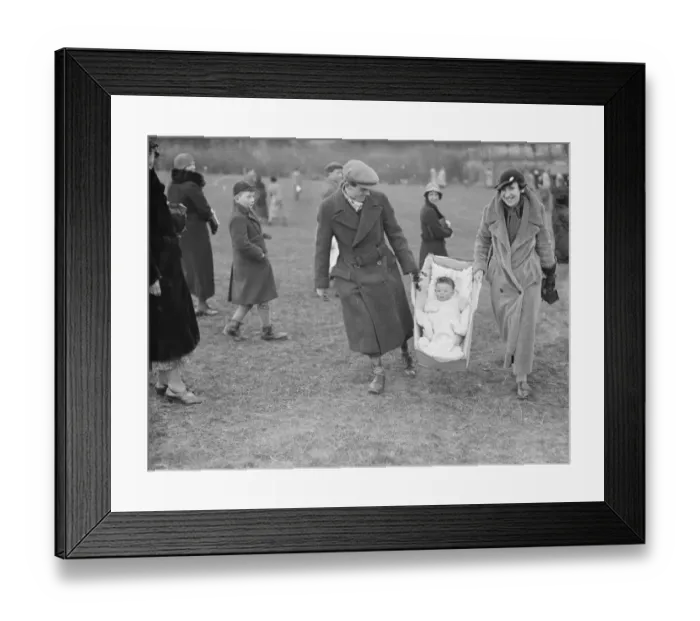 Framed Print : A young fan being carried to the races at the R A Woolwich point to point by baby carrier Framed Print : A young fan being carried to the races at the R A Woolwich point to point by baby carrier
