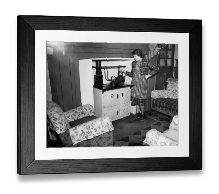 Framed Print : A woman boils to kettle for her cup of tea, in the main room of her cottage Framed Print : A woman boils to kettle for her cup of tea, in the main room of her cottage