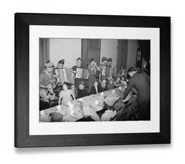 Framed Print : Children being entertained by an accordian band while they have their Christmas breakfast