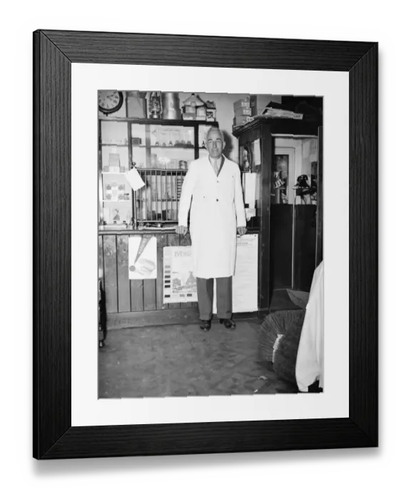 Framed Print : Mr George May, Postmaster of Downe, Kent by his Post Office counter and telephone