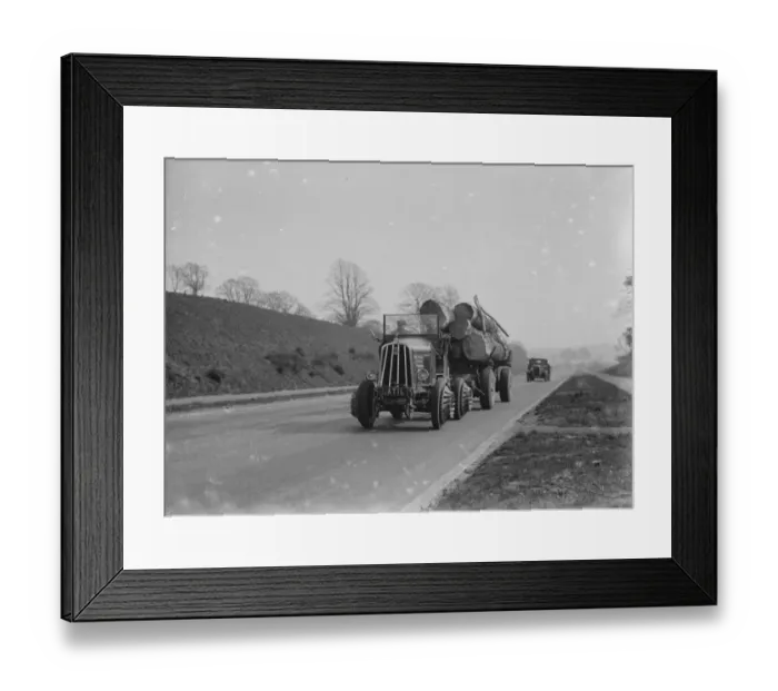 Framed Print : Heavy load of logs being towed by a tractor. 1935 Framed Print : Heavy load of logs being towed by a tractor. 1935