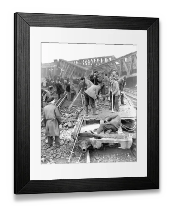 Framed Print : A man works with an acetylene cutting the remains of a train carriage in the foreground Framed Print : A man works with an acetylene cutting the remains of a train carriage in the foreground