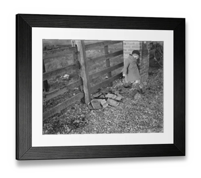 Framed Print : Children playing on the shingle beach at Dungeness. A child trys on a special Framed Print : Children playing on the shingle beach at Dungeness. A child trys on a special