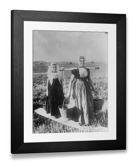 Framed Print : Two typical Dutch women women in native dress carrying pails. 12 August 1932 Framed Print : Two typical Dutch women women in native dress carrying pails. 12 August 1932