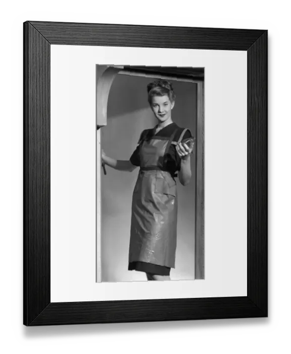 Framed Print : Woman in the 40s wearing an apron and holding a bottle 1947 Framed Print : Woman in the 40s wearing an apron and holding a bottle 1947