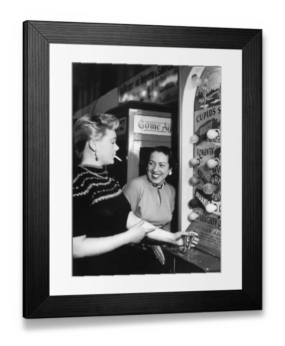 Framed Print : Two women enjoying themselves playing the Arcade machine Cupids Secret Framed Print : Two women enjoying themselves playing the Arcade machine Cupids Secret