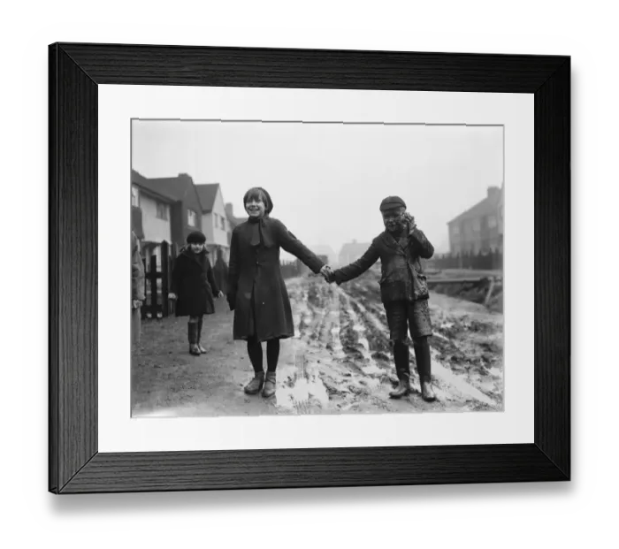 Framed Print : Fen Grove road complaint. A young boy enjoys the mud. 1937