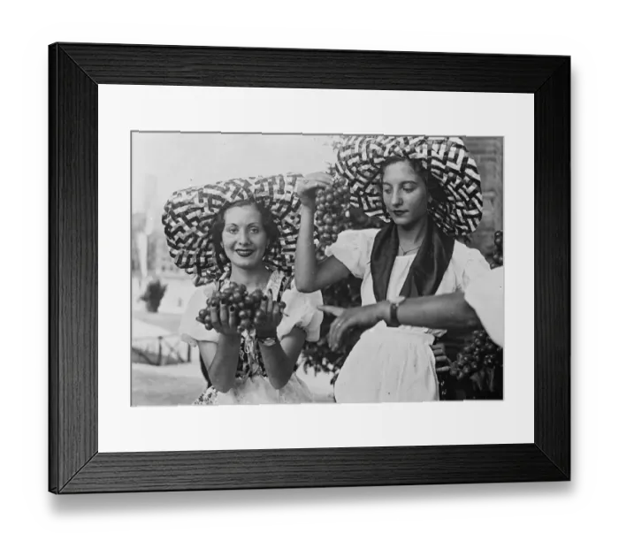 Framed Print : Two pretty Italian girls in peasant costume and broad brimmed hats offer bunches Framed Print : Two pretty Italian girls in peasant costume and broad brimmed hats offer bunches