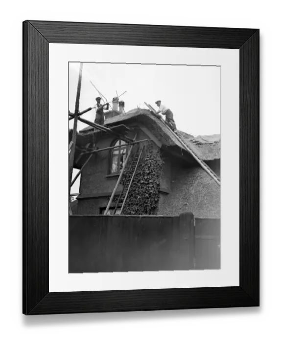 Framed Print : The craft of thatching - At work on thatching the picturesque Old Cottage ath Framed Print : The craft of thatching - At work on thatching the picturesque Old Cottage ath