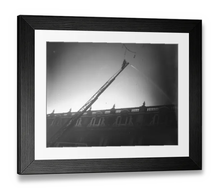 Framed Print : Madame Tussauds burned down. A fireman playing on the flames. 18 March 1925