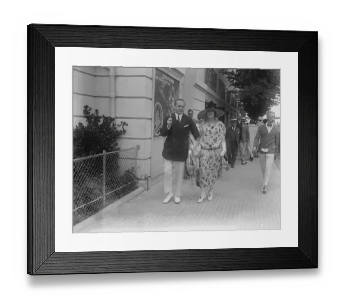 Framed Print : Society at Deauville. Mr Jeff Cohn, the famous racehorse owner, strolling with his wife Framed Print : Society at Deauville. Mr Jeff Cohn, the famous racehorse owner, strolling with his wife