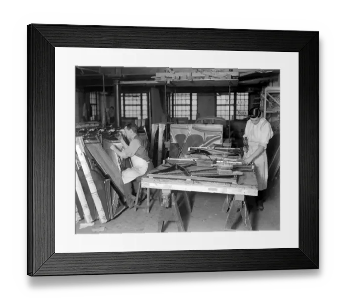 Framed Print : Piano making at Brinsmeads Factory. The man on the right is fitting in wires while