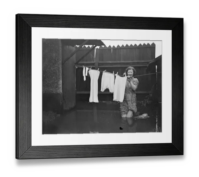 Framed Print : Knee deep in flood water a housewife hangs out her washing at Maidenhead. 1 January Framed Print : Knee deep in flood water a housewife hangs out her washing at Maidenhead. 1 January