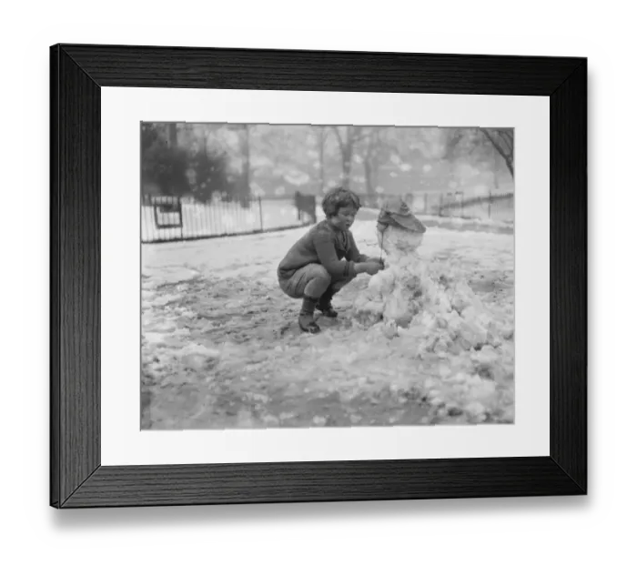 Framed Print : Little Peter Scott makes snowmen in St James Park 5 March 1922 Framed Print : Little Peter Scott makes snowmen in St James Park 5 March 1922