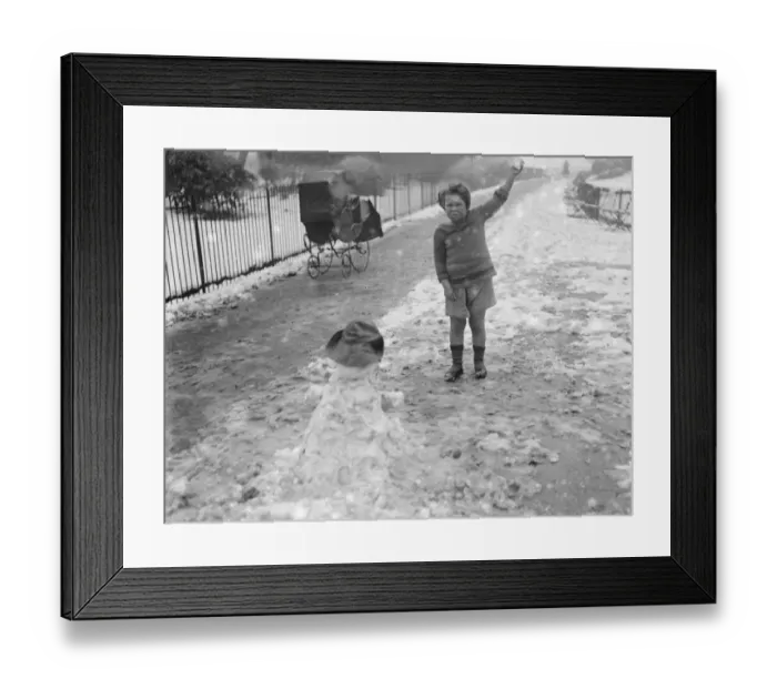 Framed Print : Little Peter Scott makes snowmen in St James Park 5 March 1922 Framed Print : Little Peter Scott makes snowmen in St James Park 5 March 1922