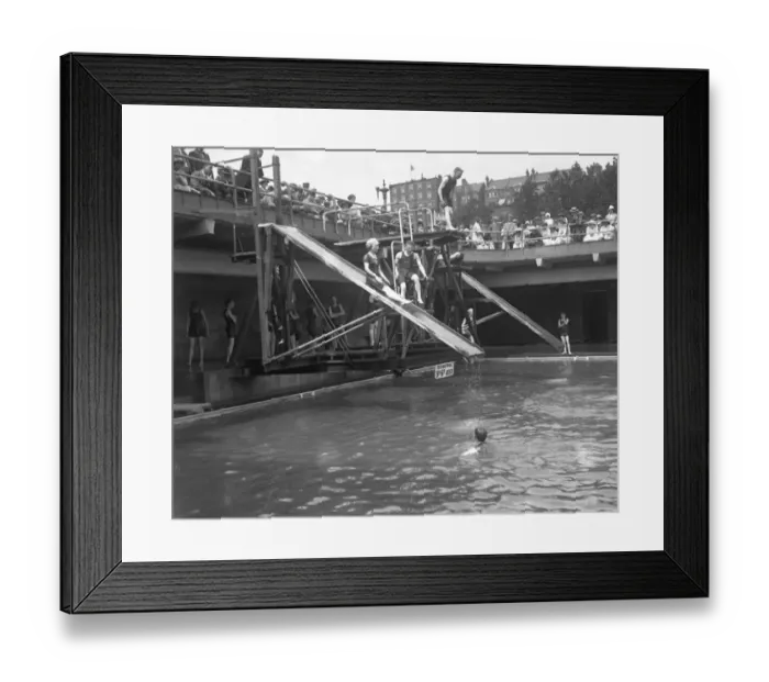 Framed Print : Swimmers enjoying the water chute and diving boards at the open air swimming pool Framed Print : Swimmers enjoying the water chute and diving boards at the open air swimming pool