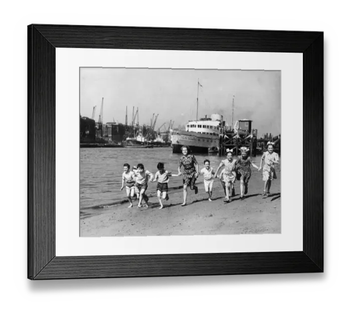 Framed Print : Summer at last, children running on the beach by the Tower of London. The pleasure Framed Print : Summer at last, children running on the beach by the Tower of London. The pleasure