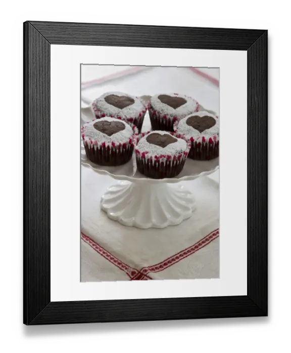 Framed Print : Five chocolate muffins decorated with icing sugar in heart shape on white cake stand credit