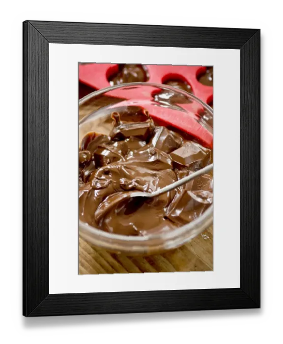 Framed Print : Melted chocolate in glass bowl with red heart mould behind credit: Marie-Louise Framed Print : Melted chocolate in glass bowl with red heart mould behind credit: Marie-Louise