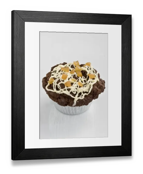 Framed Print : Chocolate muffin decorated with drizzled icing with dried mango pieces credit Framed Print : Chocolate muffin decorated with drizzled icing with dried mango pieces credit