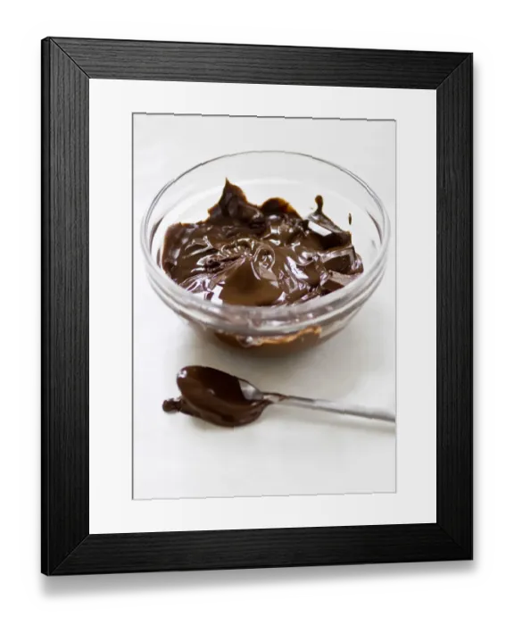 Framed Print : Glass bowl of melting chocolate with spoon on white surface credit: Marie-Louise Framed Print : Glass bowl of melting chocolate with spoon on white surface credit: Marie-Louise