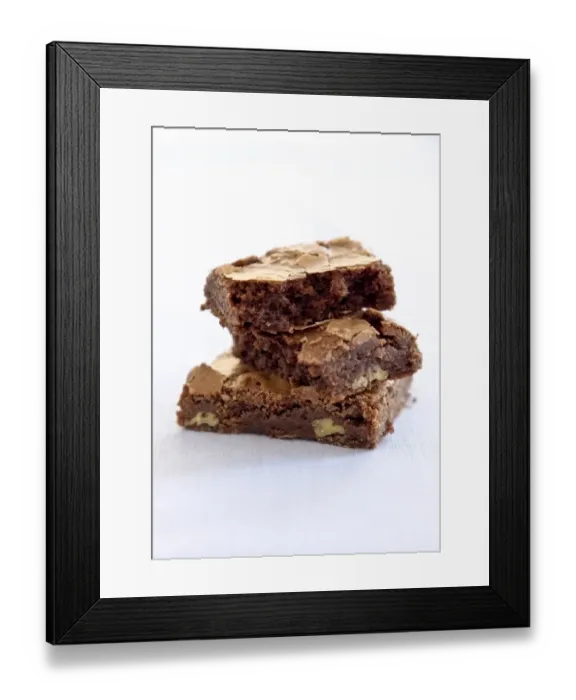Framed Print : Three chocolate brownies stacked on white background credit: Marie-Louise Avery