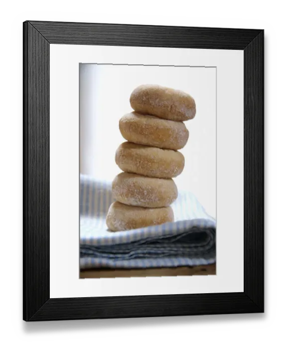 Framed Print : Mini ring doughnuts stacked on blue and white napkin credit: Marie-Louise Avery