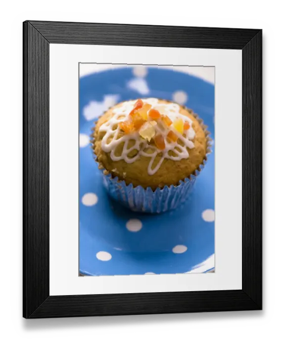 Framed Print : Muffin decorated with squiggly icing and candied peel on spotted blue plate credit Framed Print : Muffin decorated with squiggly icing and candied peel on spotted blue plate credit