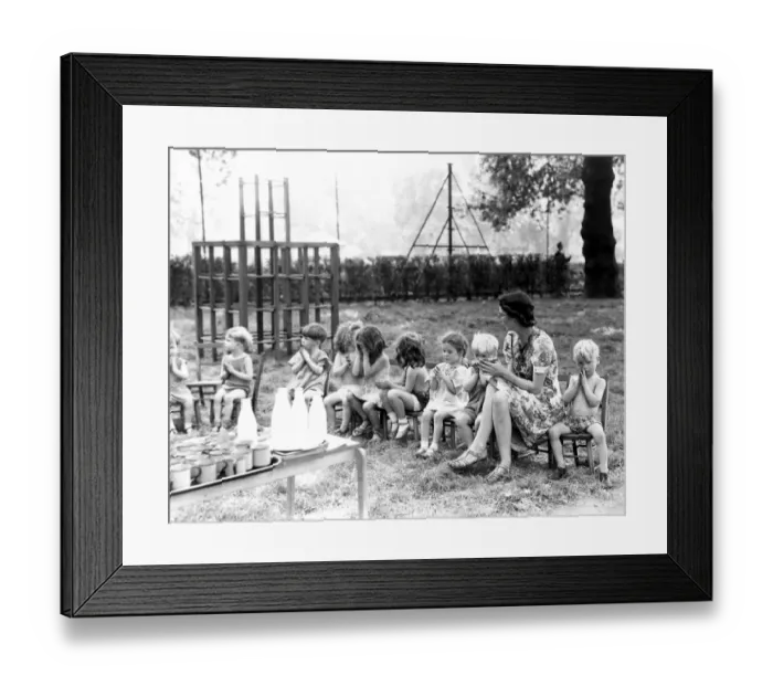 Framed Print : The children from St Leonards Day Nursery sit in a line with their nursery teacher Framed Print : The children from St Leonards Day Nursery sit in a line with their nursery teacher