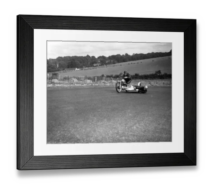 Framed Print : John Surtees hangs over the motorcycle side - car to balance the wheel as his father Framed Print : John Surtees hangs over the motorcycle side - car to balance the wheel as his father