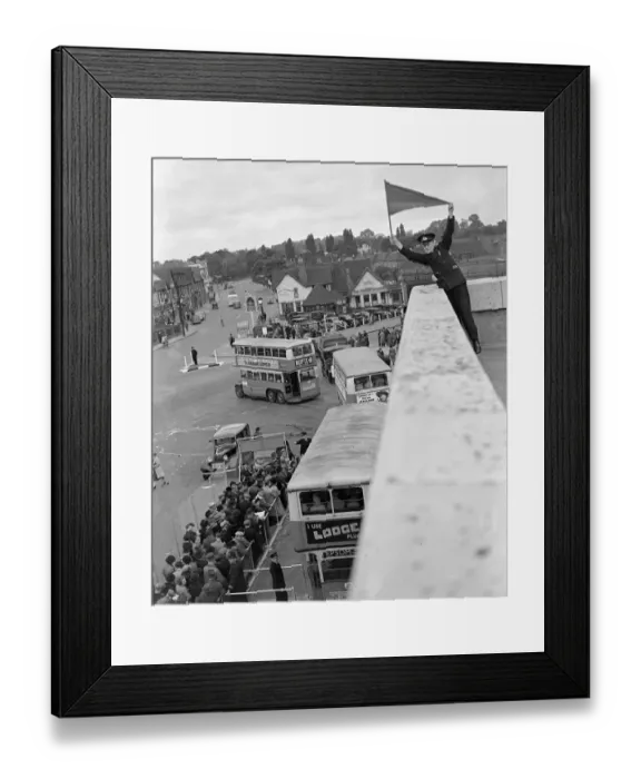 Framed Print : Derby Day in Epsom, Surrey. A Bus official signalling the double - decker buses Framed Print : Derby Day in Epsom, Surrey. A Bus official signalling the double - decker buses