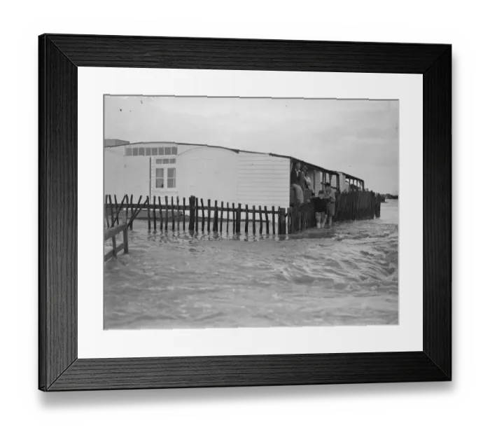 Framed Print : Sea defences broken by flood tide at Winchelsea, bungalows flooded and holidaymakers