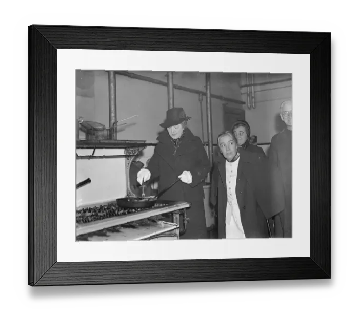 Framed Print : Premiers wife, fries sausages, during East end hostel visit. Mrs Neville Chamberlain