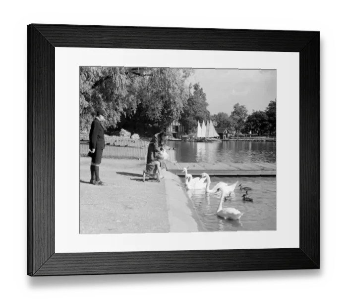Framed Print : A day out at Regents Park, London - a mother with a child in a pushchair feeding Framed Print : A day out at Regents Park, London - a mother with a child in a pushchair feeding