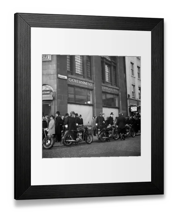 Framed Print : The window blinds are drawn, and motor cycle and foot policemen stand guard outside Framed Print : The window blinds are drawn, and motor cycle and foot policemen stand guard outside