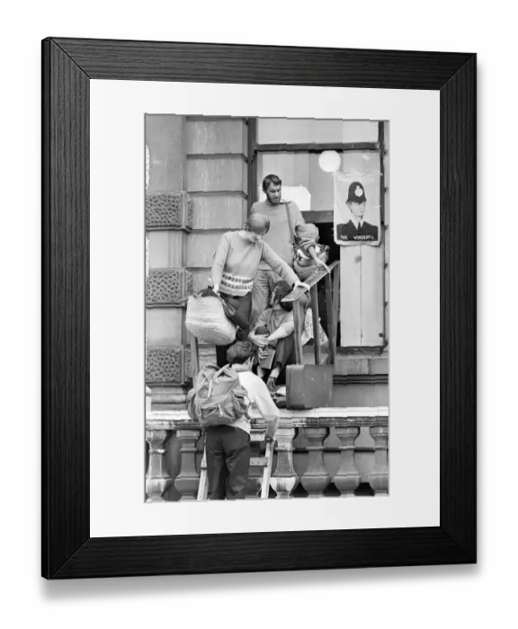 Framed Print : London: A women and child is assisted by squatters to enter the empty 60 room mansion a 144
