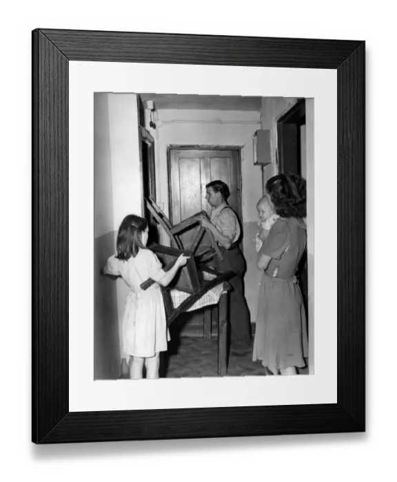 Framed Print : Helped by his 10 yesr old daughter Patricia, Mr Crome barricades the door of his Framed Print : Helped by his 10 yesr old daughter Patricia, Mr Crome barricades the door of his