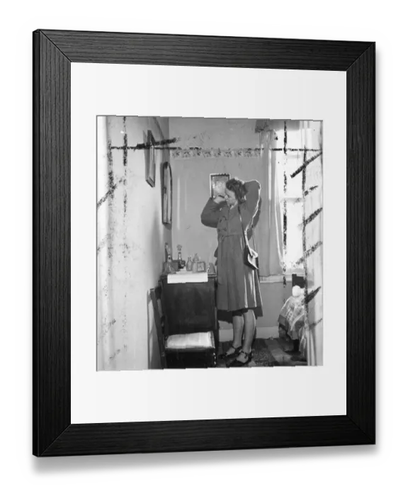 Framed Print : Woman brushing hair in front of the mirror in her bedroom. [no caption, location Framed Print : Woman brushing hair in front of the mirror in her bedroom. [no caption, location