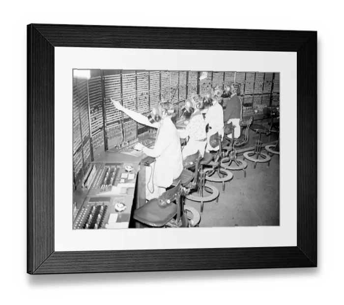 Framed Print : Telephone girls learn to carry on as usual in gas masks. Telephone girls are being