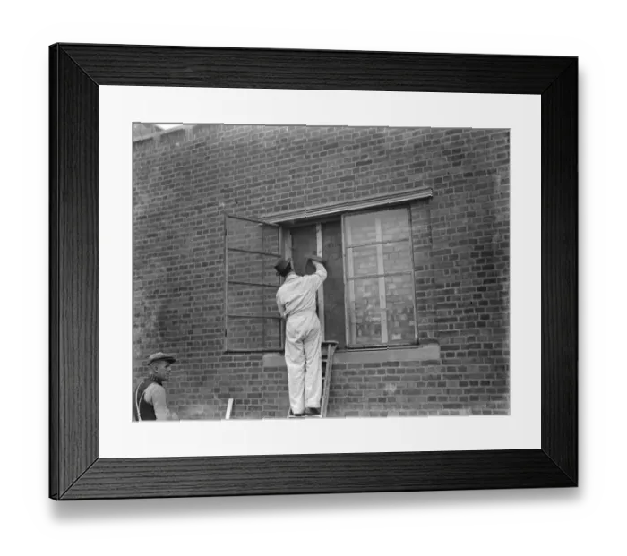 Framed Print : A modern police station on Wellhall Road, Eltham, London. A worker is plastering over a window