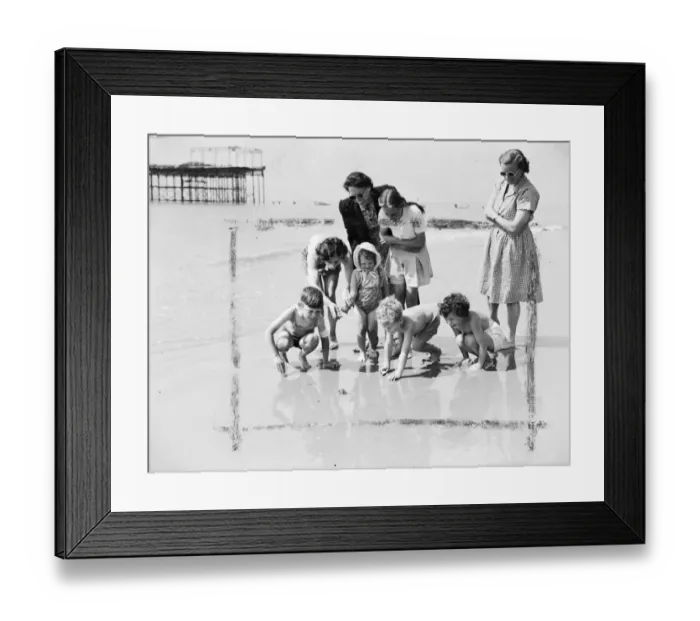 Framed Print : Happy young holidaymakers at St Leonards on Sea show keen interest but keep their Framed Print : Happy young holidaymakers at St Leonards on Sea show keen interest but keep their