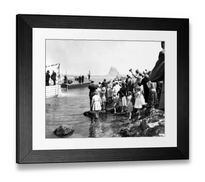 Framed Print : Crowds line the shore on Holy Island as the royal barge approaches the landing stage