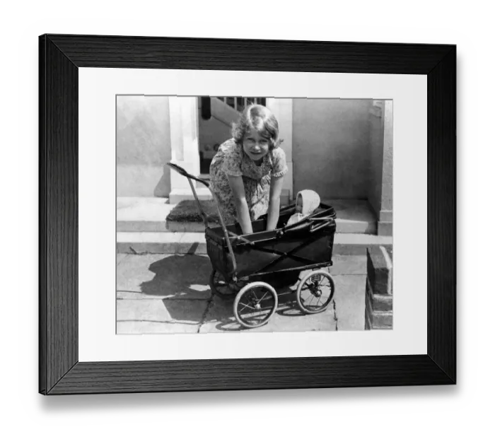 Framed Print : Princess Elizabeth playing with a dolls pram at the little house given to her